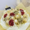 sejambak coklat elegan dengan ferrero rocher dan mawar berkilauan berkilauan dalam emas dan merah, dibalut dengan rona kuning lembut berlapis dengan reben merah jambu.