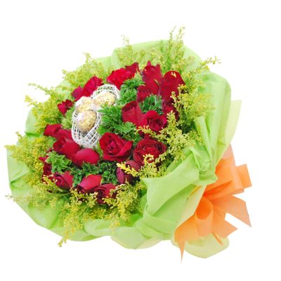 bouquet of red roses with ferrero rocher chocolates surrounded by vibrant fillers, wrapped in green.