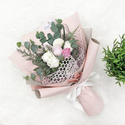 a bouquet of pink roses, white roses, white chrysanthemum, eucalyptus and fillers in a pink wrapper.