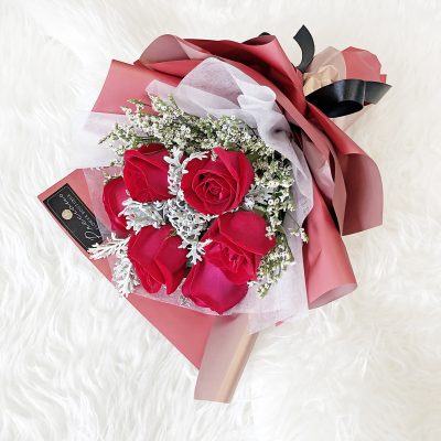 a charming bouquet of 6 stalks of red roses and silver leaf accents in a red wrapper.