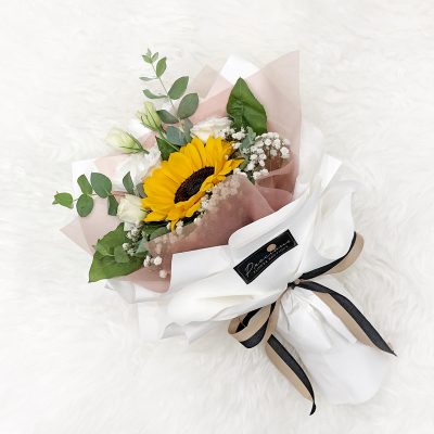 bouquet of sunflower, white eustoma, baby’s breath, and green leaves in a white wrapper.