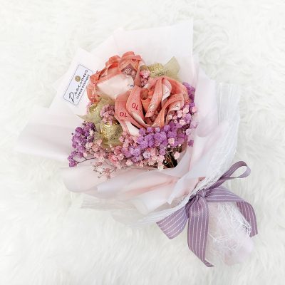 bouquet with money rose, ferrero rocher and coloured baby’s breath in pink wrapping with purple ribbon.