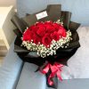 bouquet of 20 stalks red roses surrounded by baby’s breath in black wrapper with red ribbon.