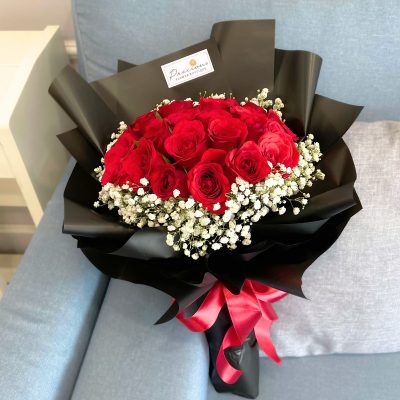 bouquet of 20 stalks red roses surrounded by baby’s breath in black wrapper with red ribbon.