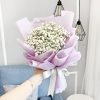 bouquet of white baby’s breath wrapped in pastel purple wrapper with white ribbon.