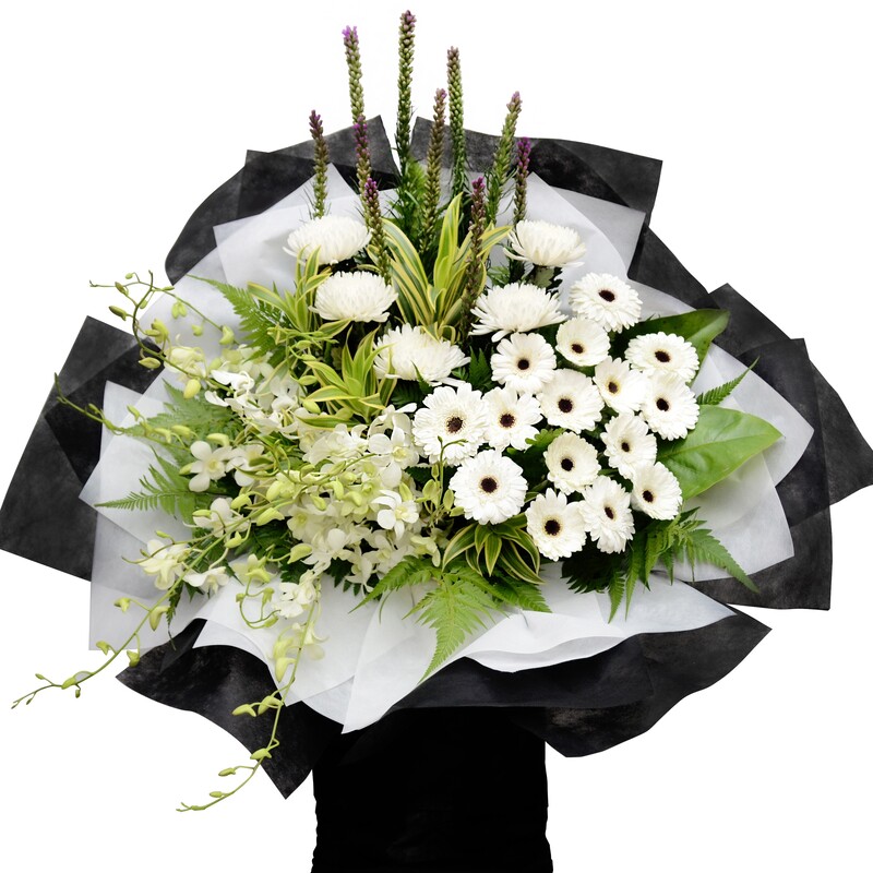 funeral flower stand featuring white chrysanthemum, white orchid, white gerbera, and liatris with layered black and white wrapping.