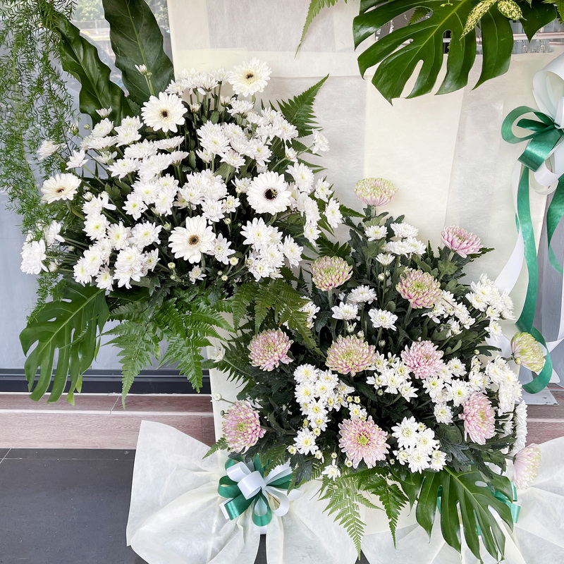 arranged in fresh white lilies, chrysanthemums, and hydrangea, this funeral bouquet stand showcases a balanced and elegant floral tribute