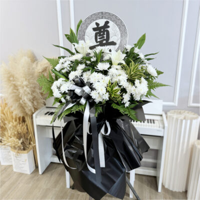 flower stand featuring white madonna lily and chrysanthemum pompom with black and silver ribbons