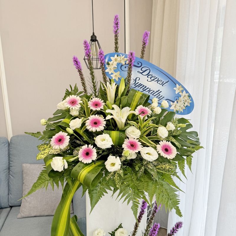 a flower stand of mixed flowers including casablanca lily, liatris spikes, pink gerbera, and white eustoma