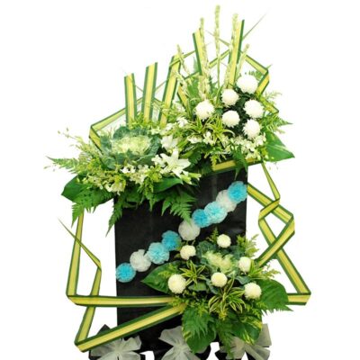 funeral flower stand featuring white chrysanthemum, white orchid, white casablanca lily, brassica and greenery in a structured arrangement