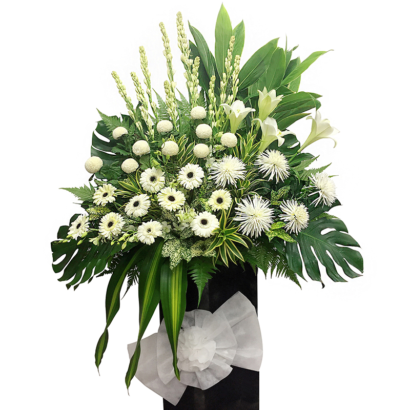 funeral stand featuring white chrysanthemum, white orchid, gerbera, and other white flowers with lush green leaves in a tall arrangement about 185cm.