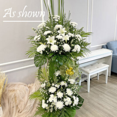funeral flower stand with white madonna lily and chrysanthemum in a tall green leafy arrangement