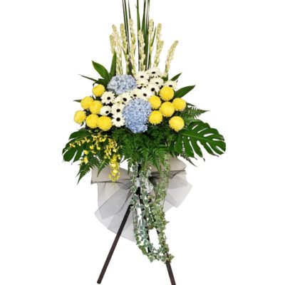 flower stand of funeral with white gerbera, yellow chrysanthemum, blue hydrangea and tall tuberosa on a wooden stand