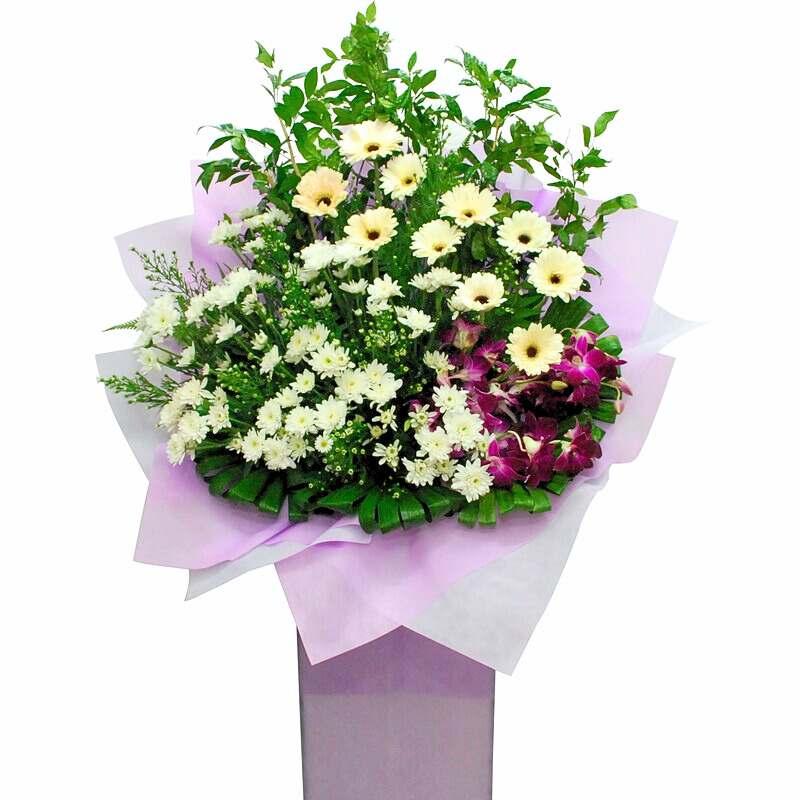 flower bouquet stand featuring white gerbera, white chrysanthemum pompom, and purple orchid with green leaves wrapped in soft purple paper.