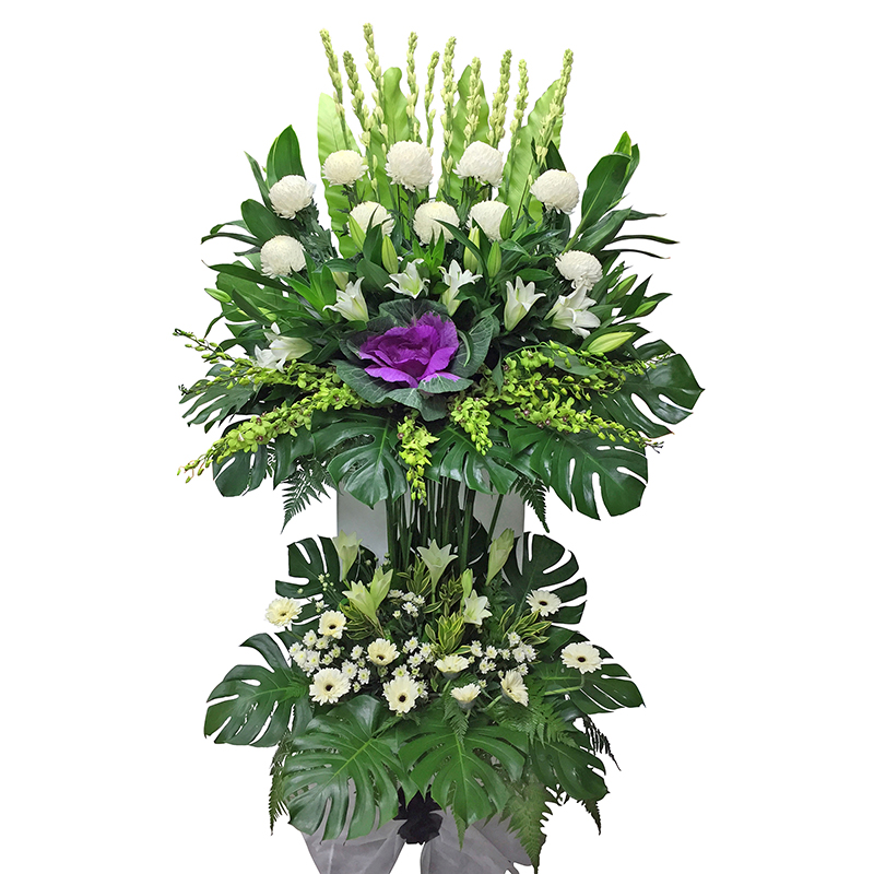 funeral flower stand featuring white chrysanthemum, casablanca lily, green orchid and purple Brassica with lush green leaves