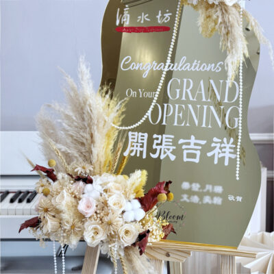 elegant flower stand featuring preserved flowers and cotton flowers accented with dried leaves and grasses on a mirror base with grand opening text