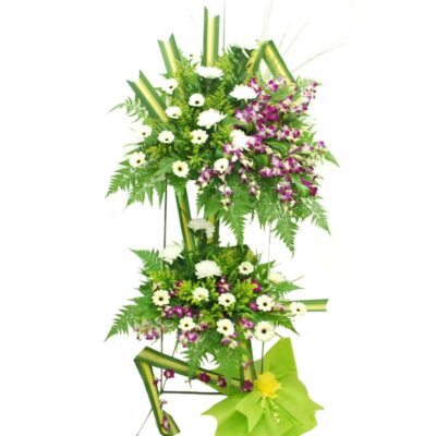 funeral flower stand featuring white gerbera, chrysanthemum, and purple orchids accented with lush greenery in a layered arrangement