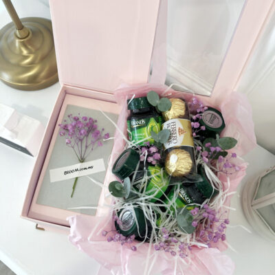 a delicate flower arrangement with purple baby's breath accompanying six essence of chicken bottles and ferrero rocher chocolates in a pink gift box.
