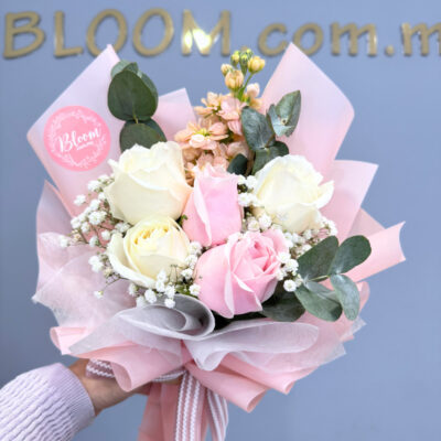 flower bouquet featuring a mix of white rose, pink rose, matthiola, and baby's breath with layered pink wrapping