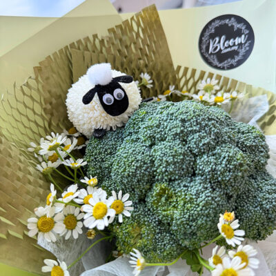 bouquet with broccoli and chamomile flowers accented by a cute sheep figure in green wrapping