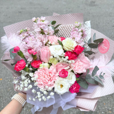 a bouquet featuring pink matthiola, pink carnation, white eustoma, and delicate baby's breath with feather decoration