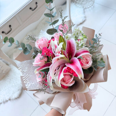flower bouquet featuring pink stargazer lily, pink roses, white matthiola and carnation spray wrapped in soft beige paper
