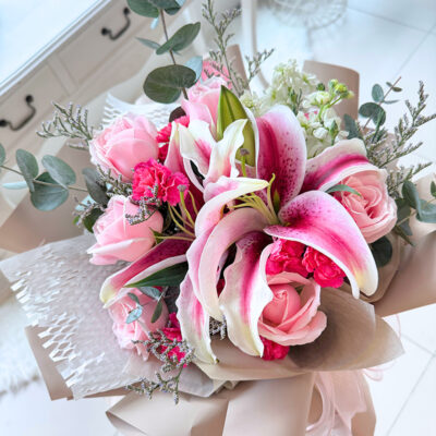 a bouquet of pink roses and white matthiola with pink stargazer lily and caspia flower arranged in delicate style