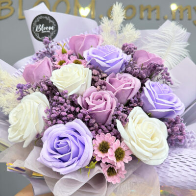 wrapped in soft lilac paper, this bouquet includes purple and white soap roses accented with delicate preserved baby's breath and soap chamomile