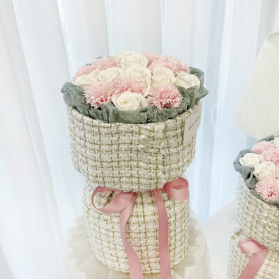 flower bouquet with pink soap carnations and white soap roses wrapped in textured fabric with pearl accents and pink ribbon